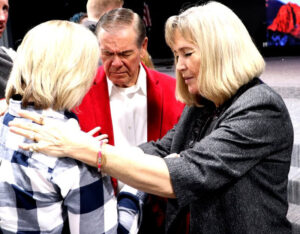 Jimmy and Anne Alexander praying over a woman